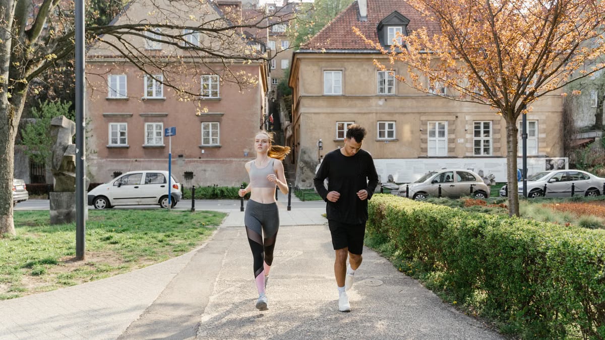 A couple jogging together in an urban park, enjoying outdoor exercise.